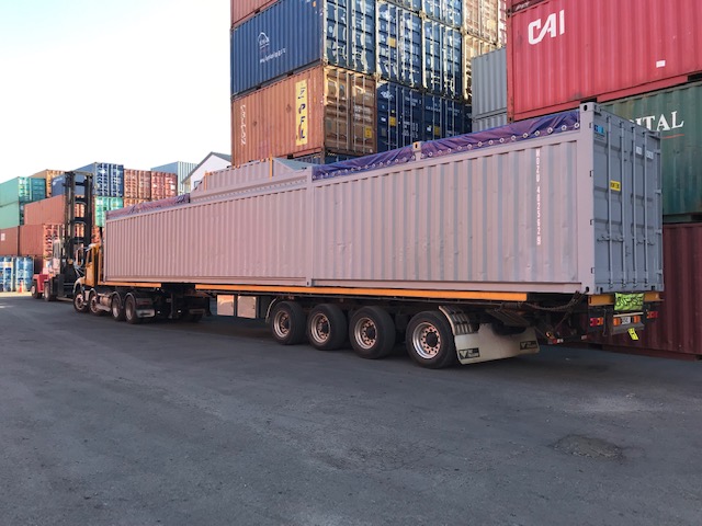 Long and low containerised project cargo on a truck at the port